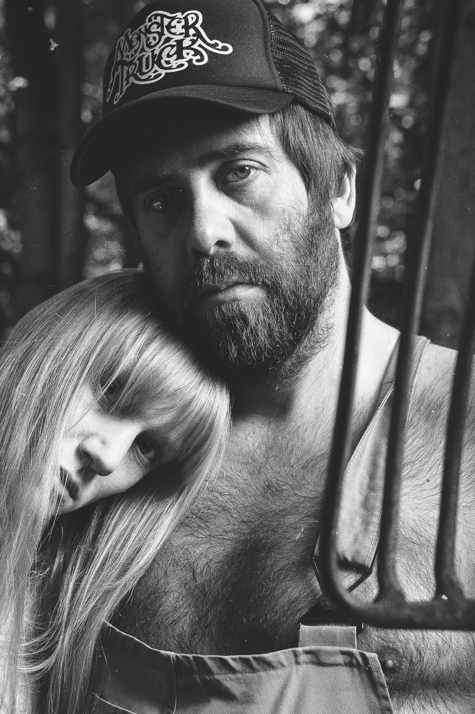 Close-up black and white portrait of a woman leaning her head on a man's shoulder.